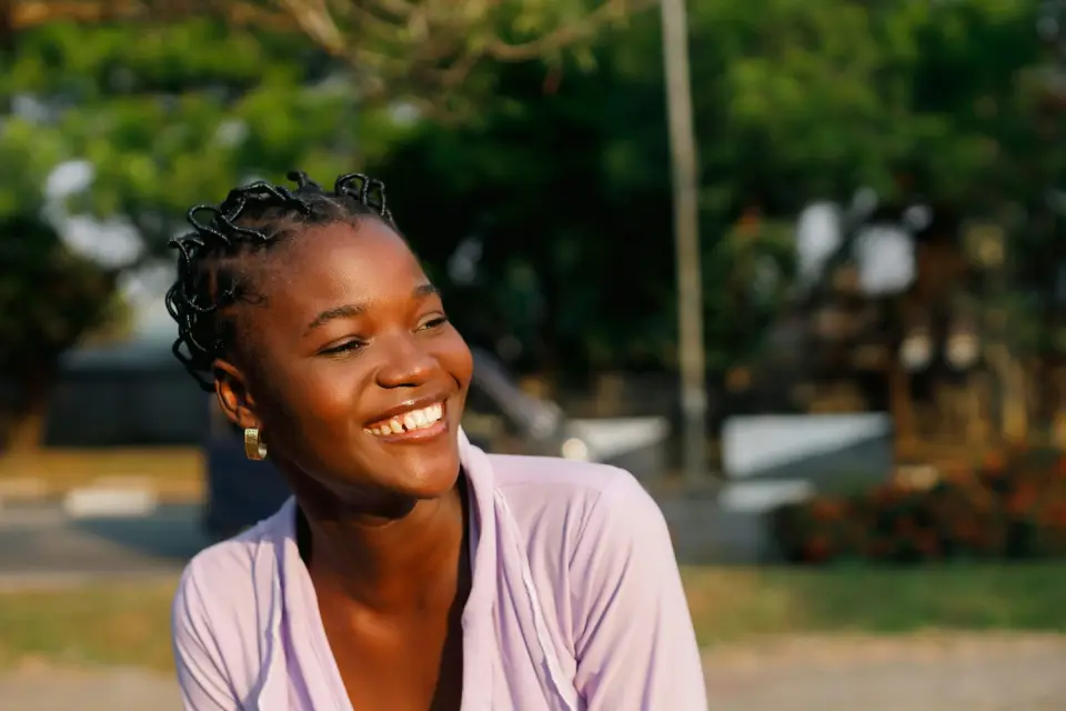 A smiling woman outdoors in warm natural light