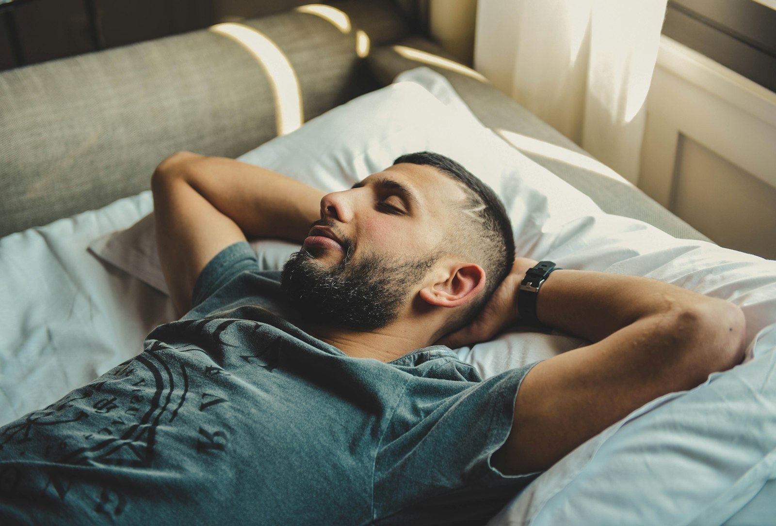 Man resting in bed in soft morning light — deeper sleep is the first change most people report on sermorelin