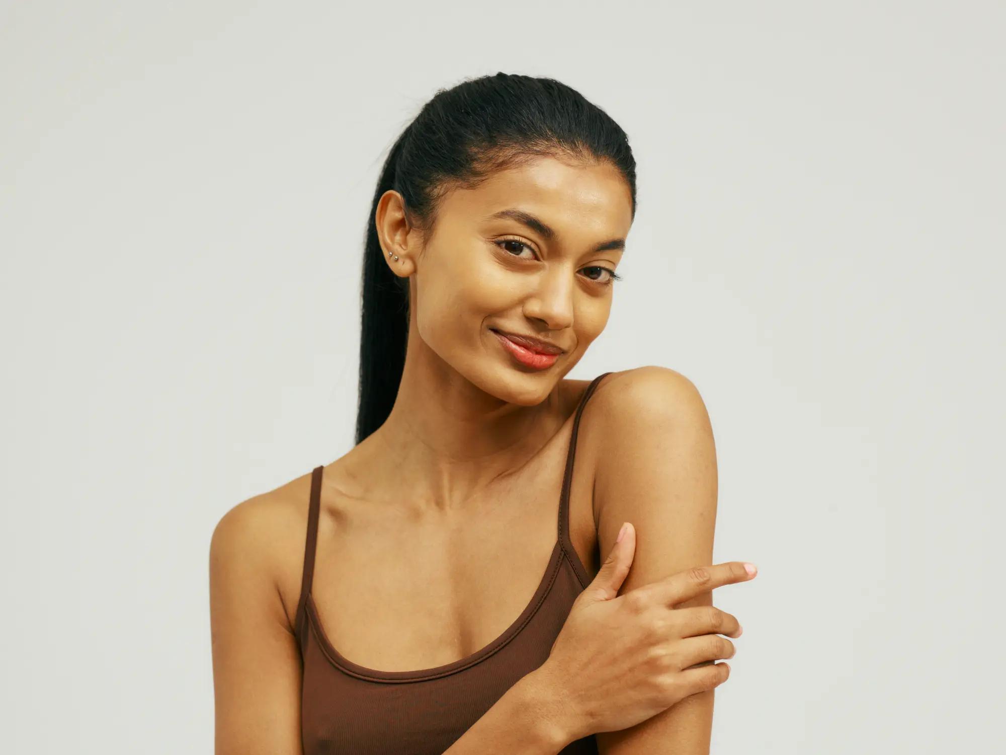 Woman with a soft, confident expression against a grey backdrop